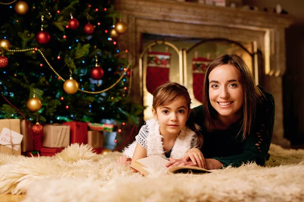 Çocuk ile anne Noel kitap okumak — Stok fotoğraf