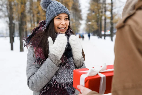Girl looking at her boyfriend giving her present — Stock Photo, Image