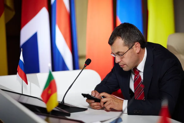 Modern politician with smartphone — Stock Photo, Image