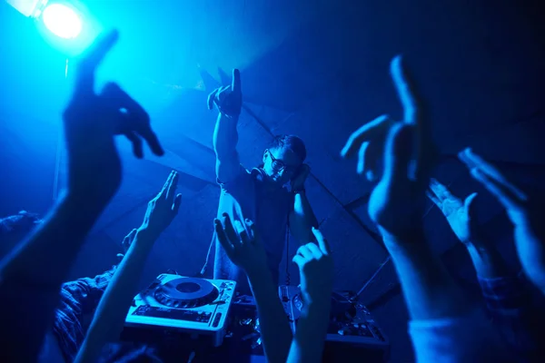 Deejay enjoying music among energetic dancers — Stock Photo, Image