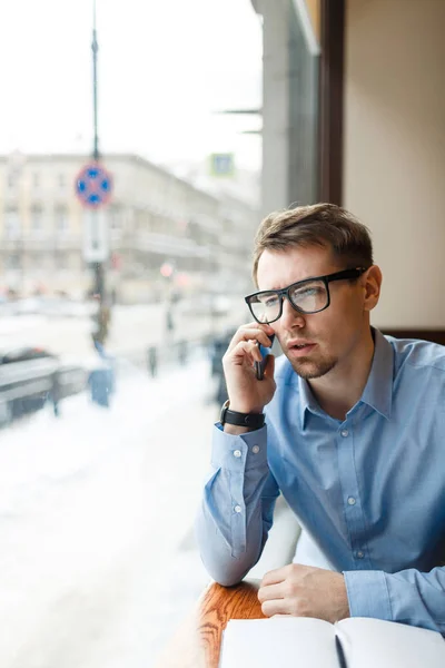 Бизнесмен в очках говорит по мобильному телефону — стоковое фото
