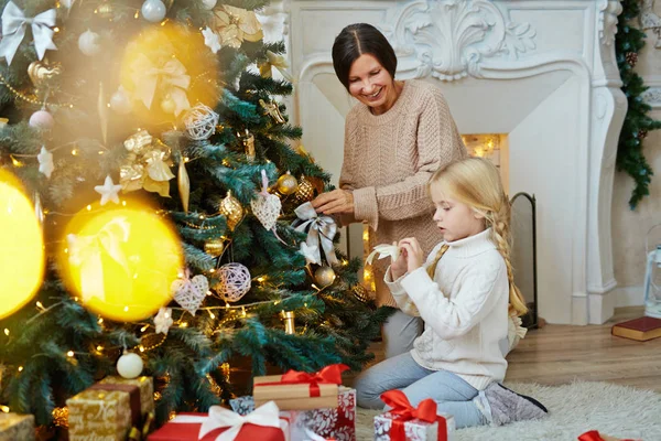 Meisje en vrouw versieren kerstboom — Stockfoto