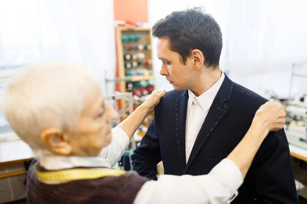 Empresario probándose la chaqueta — Foto de Stock