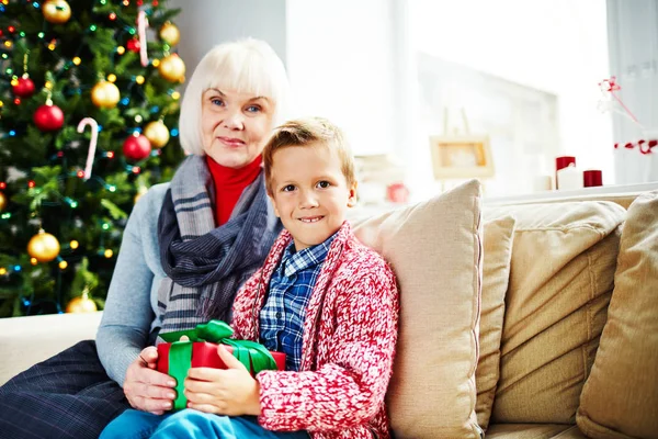 Reife Frau mit ihrem Enkel am Weihnachtsbaum — Stockfoto