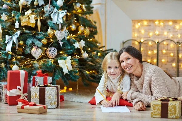 Menina e mulher madura pela árvore de natal — Fotografia de Stock