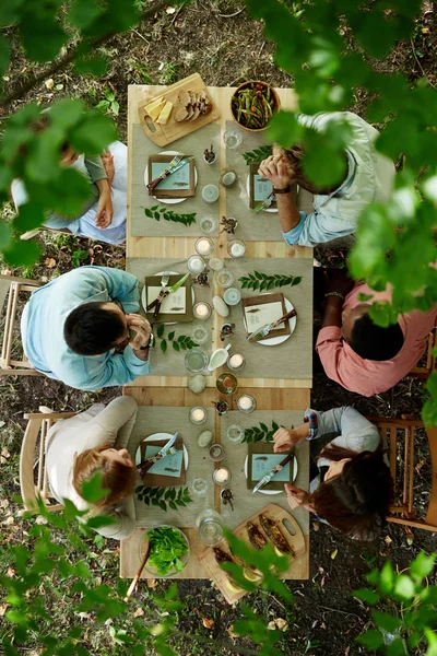 Friends sitting by Thanksgiving table — Stock Photo, Image