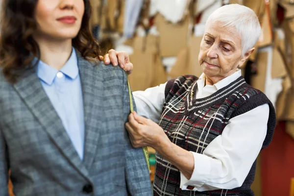 Forretningskvinne prøver ny jakke – stockfoto