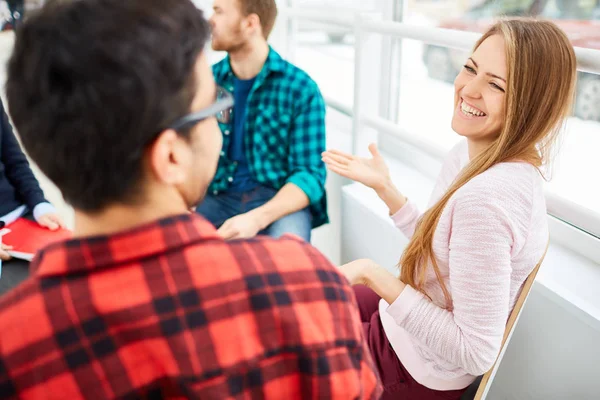 Meisje glimlachend op haar klasgenoot tijdens gesprek — Stockfoto