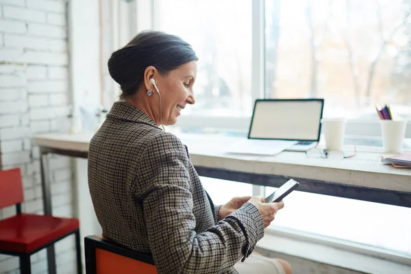 Woman choosing soundtrack in her smartphone — Stock Photo, Image