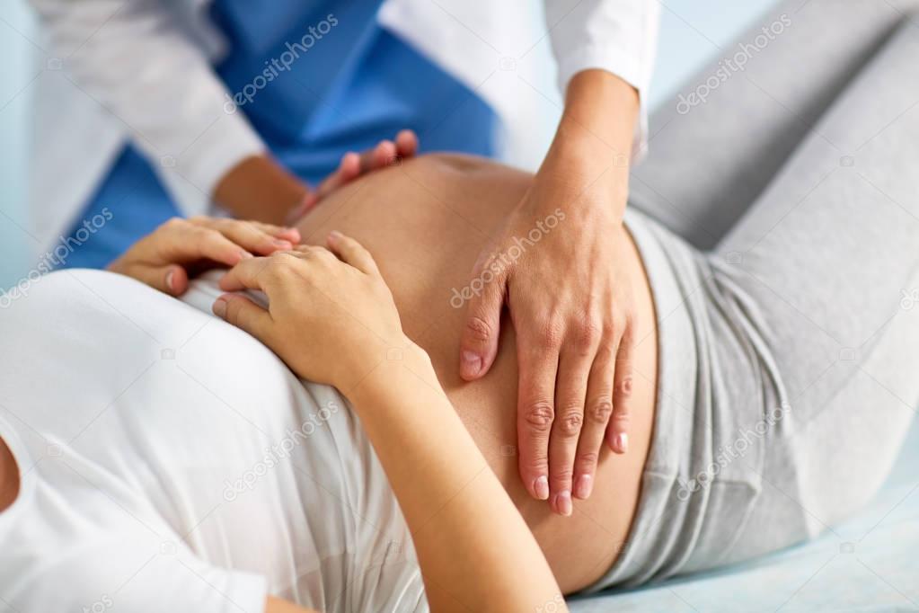 obstetrician touching belly of pregnant woman
