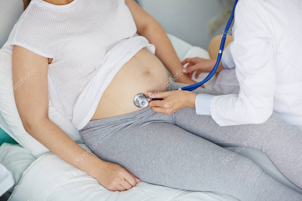 Obstetrician examining her pregnant patient 