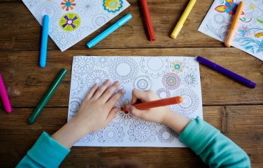 Kid coloring pics with felt pens clipart