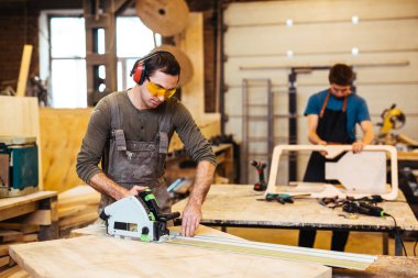 Erkekler elektrik fretsaw ile çalışma