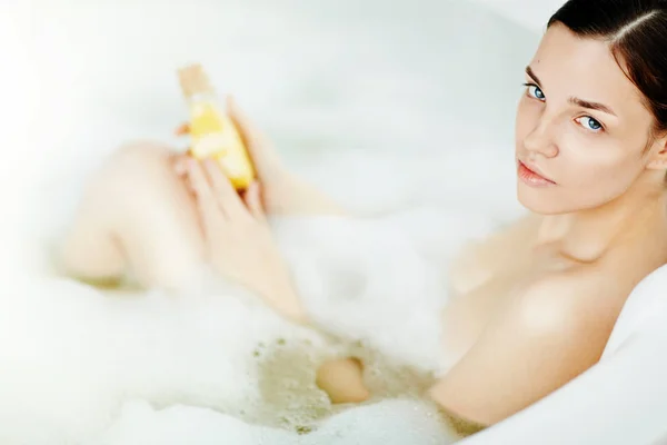 Mujer joven con producto para el cuidado del cuerpo — Foto de Stock