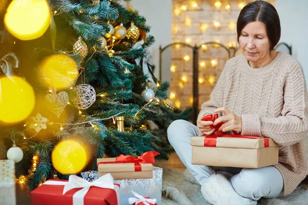 Woman tying ribbon on gift-box — Stock Photo, Image