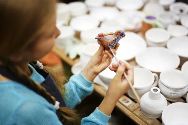 Girl painting clay bird — Stock Photo, Image