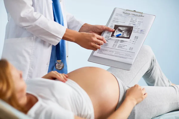 Förlossningsläkare visar sonogram av foster — Stockfoto