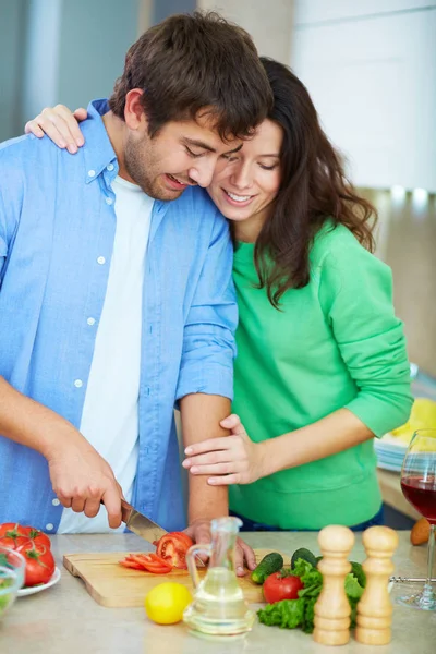 Vrouw op zoek naar haar echtgenoot koken salade — Stockfoto