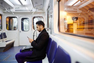 Metro'da Smartphone kullanarak iş adamı 