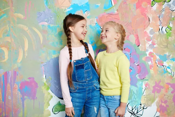 Meisjes permanent tegen gekleurde muur — Stockfoto