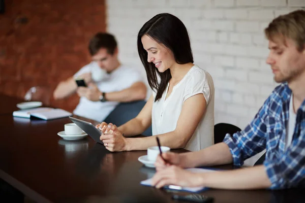 Personas sentadas a la mesa y trabajando — Foto de Stock