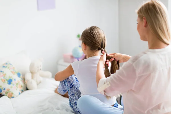 Mulher entranhando seu cabelo filha — Fotografia de Stock