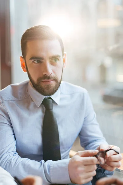 Empresario sosteniendo anteojos — Foto de Stock