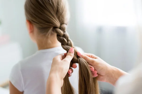 Woman plaiting her daughter hair — Stock Photo, Image