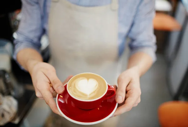 Waiter holding cup with latte — Stock Photo, Image