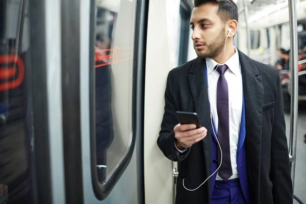 Людина в машині метро використовує смартфон — стокове фото
