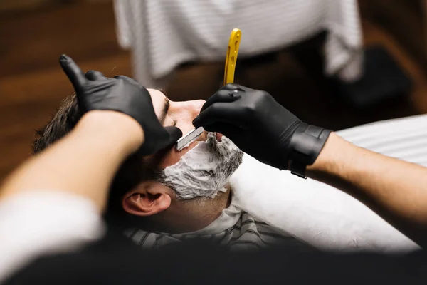 Barber shaving beard — Stock Photo, Image