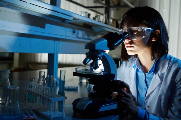 Mujer mirando en el microscopio —  Fotos de Stock