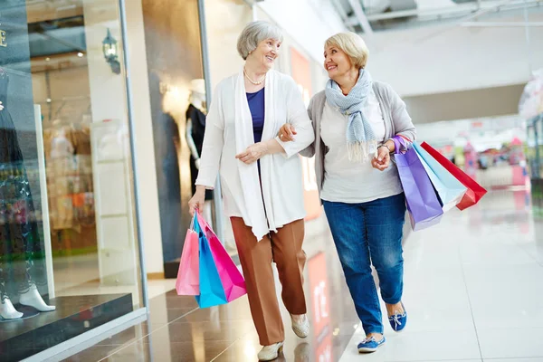 Donne che camminano lungo la vetrina — Foto Stock