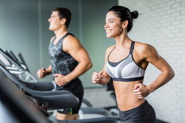 Woman and man running on treadmill