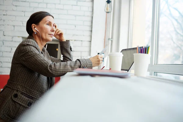 Mulher com fones de ouvido sentado no café — Fotografia de Stock