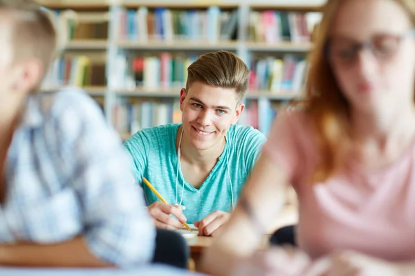 Estudiantes sentados junto al escritorio en la lección — Foto de Stock