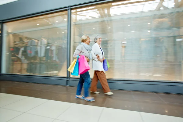 Donne che camminano lungo la vetrina — Foto Stock