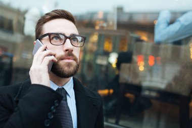 smartphone üzerinde konuşan işadamı