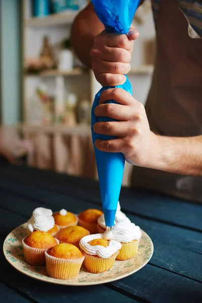 Homem que decora muffins — Fotografia de Stock