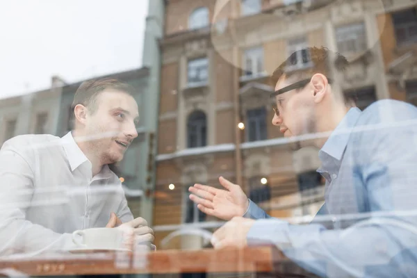 Jonge mannen communiceren in café — Stockfoto