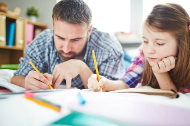 Baba ve kızı ödev yapıyor.