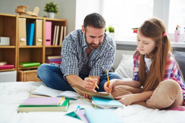 Baba ve kızı ödev yapıyor.