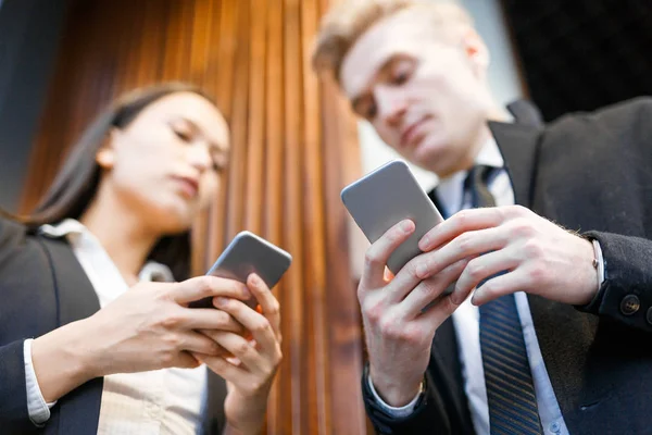 Бізнесмени обмінюються повідомленнями на смартфонах — стокове фото