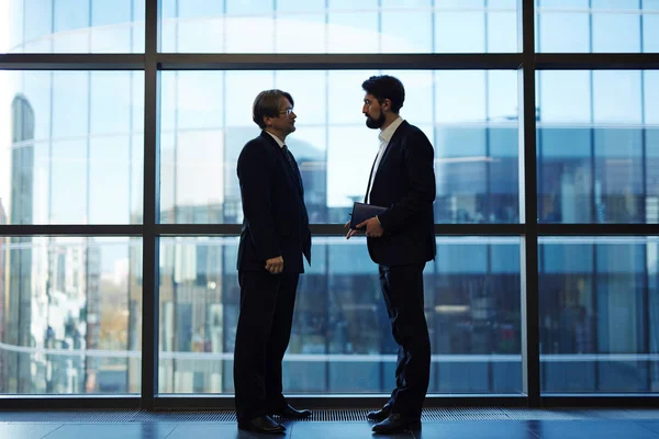 Hombres de negocios hablando en compañía — Foto de Stock