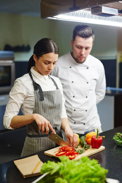 Aprendiz cortando pimientos — Foto de Stock