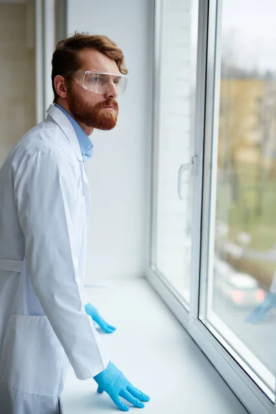 Läkaren tittar genom lab fönster — Stockfoto