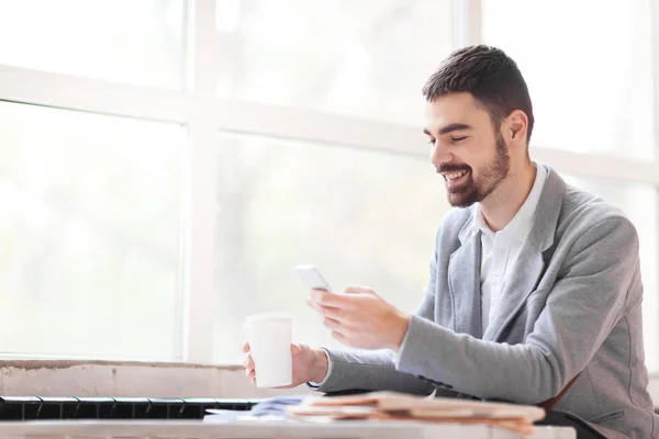 Zakenman met drankje messaging — Stockfoto