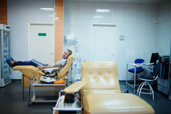 Волонтер, сидящий в клинике — стоковое фото