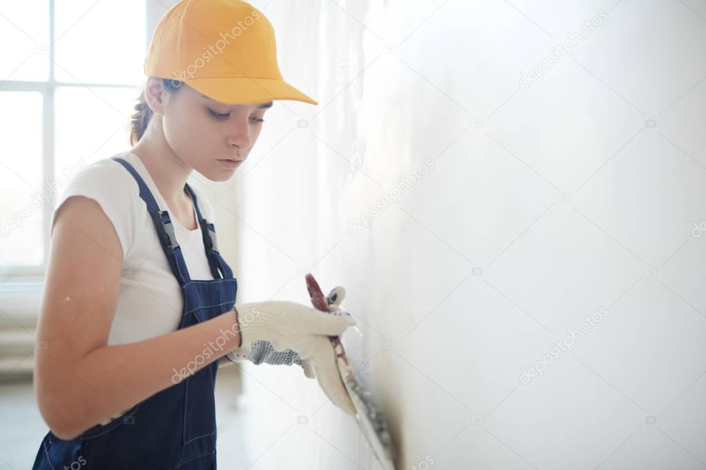 female repairperson carrying out plasterwork