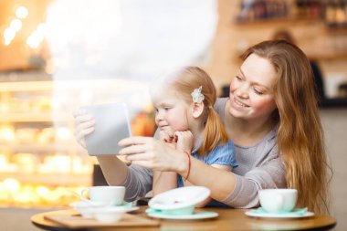 Anne ve kızı tablet üzerinde oynama